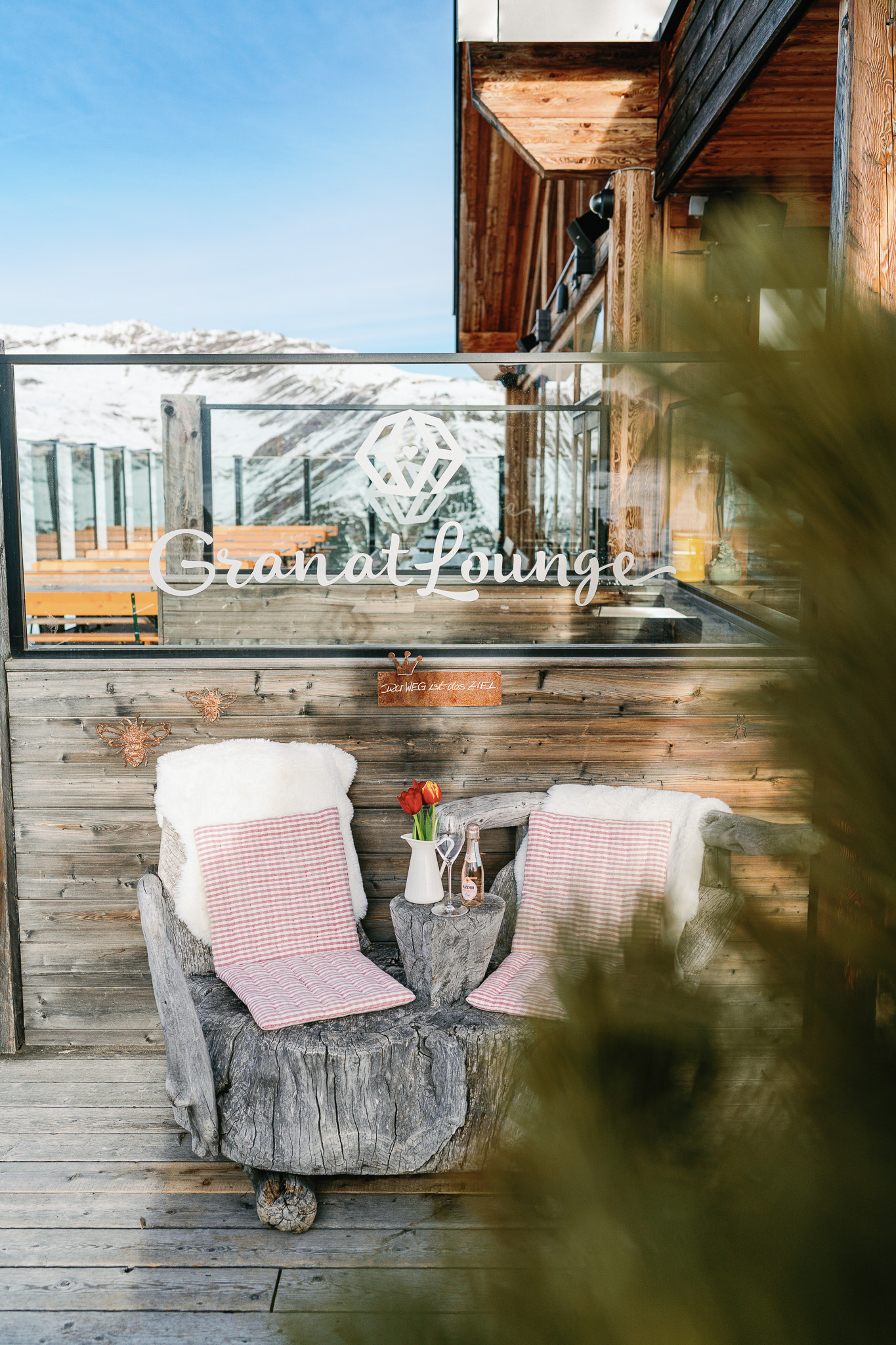 Das Bild zeigt eine Außenaufnahme der Granat Lounge mit Tischen und einer Bergkulisse im Hintergrund.