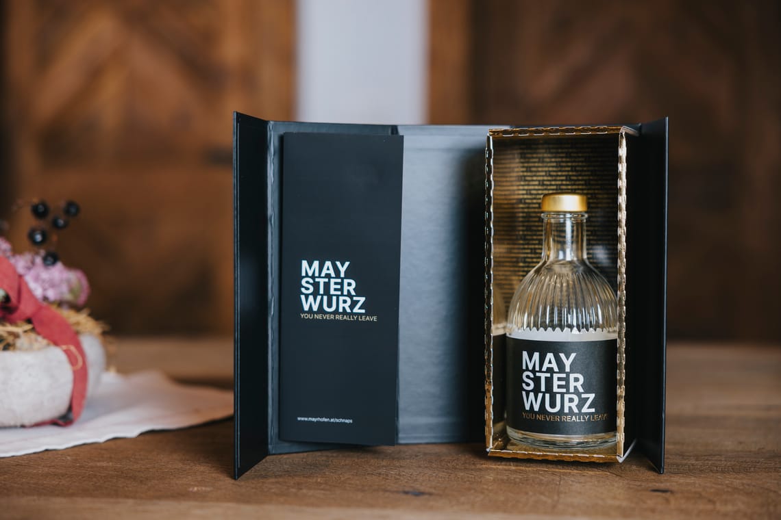 Edelbrand Maysterwurz Edle Geschenkverpackung mit einer Flasche „Maysterwurz“-Edelbrand. Die schwarze Box ist geöffnet und präsentiert die Glasflasche mit goldenem Verschluss in einem stilvollen Innenrahmen.