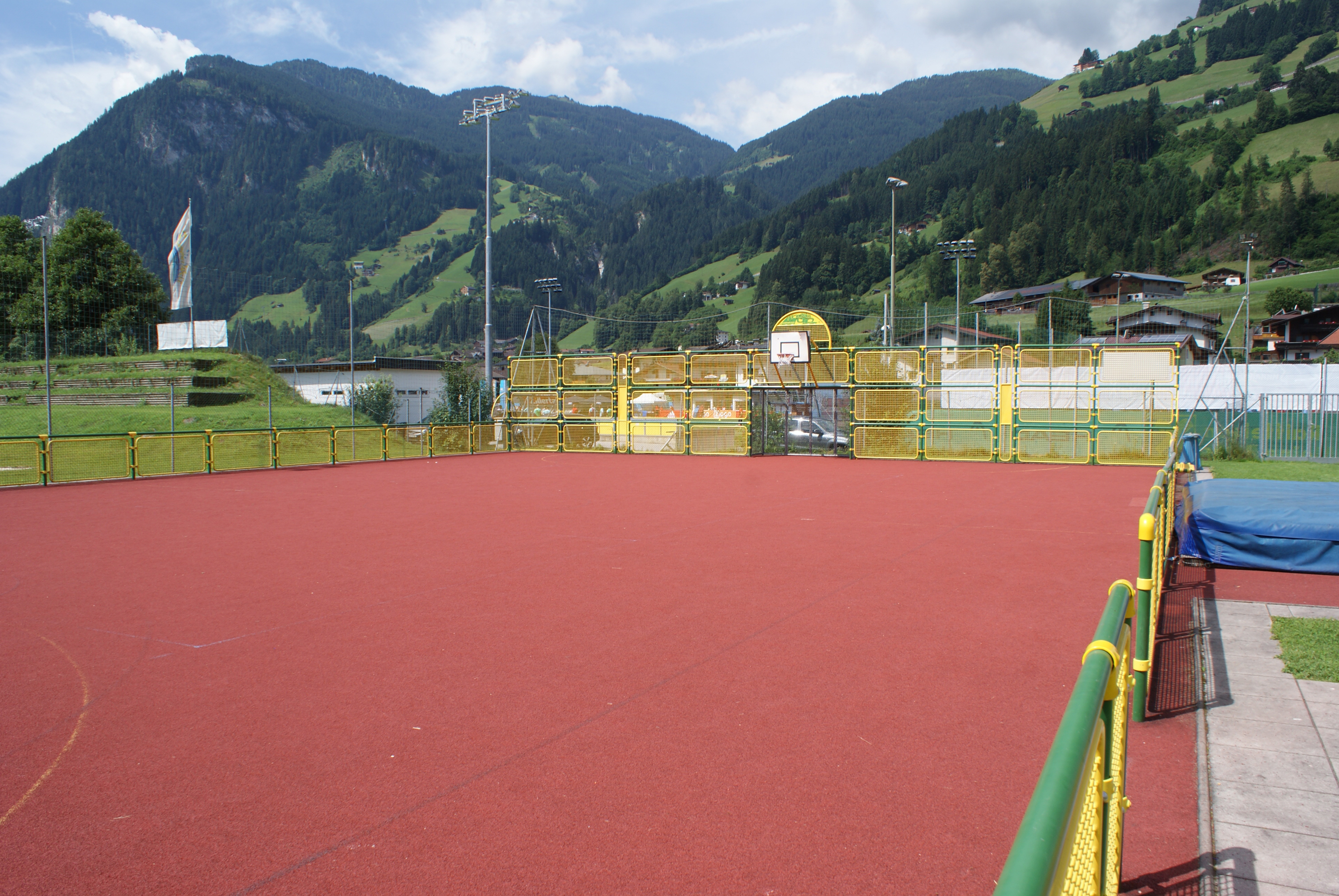 Fun Court at Sommerwelt Hippach with basketball hoops and football goals, surrounded by Alpine scenery and green sports facilities in Tyrol.