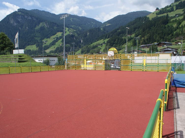 Fun-Court der Sommerwelt Hippach mit Basketballkörben und Fußballtoren, umgeben von Alpenpanorama und grüner Sportanlage in Tirol.