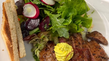 Teller mit Essen, Salat, Steak mit Kräuterbutter und frischem Salat