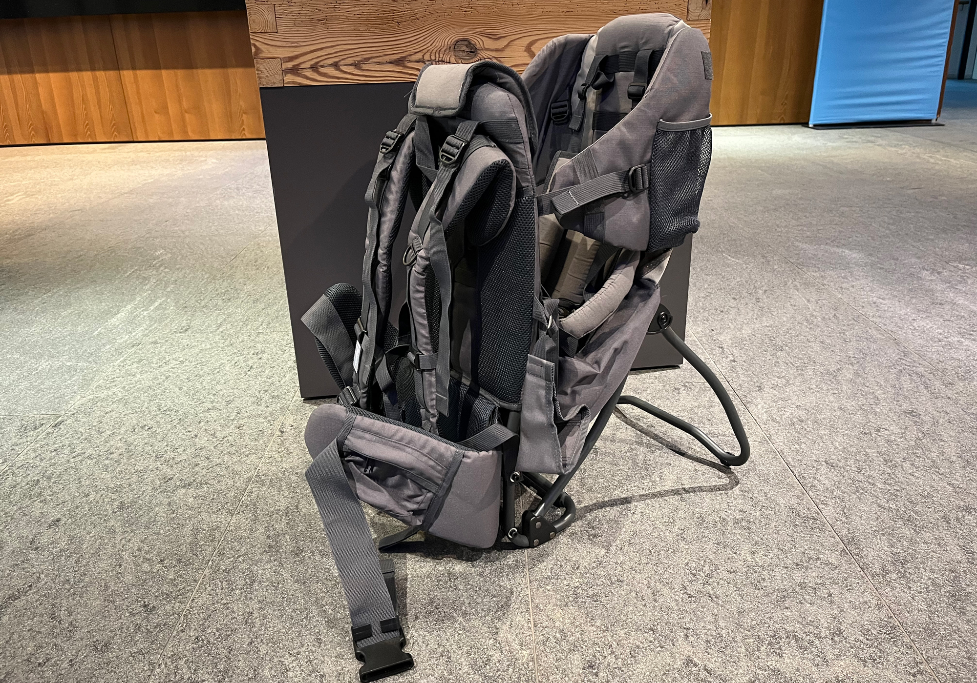 Modern child carrier backpack with sun canopy standing in front of a building in Mayrhofen, Zillertal – quality rental hiking carrier for safely walking with kids in the Tyrolean Alps.