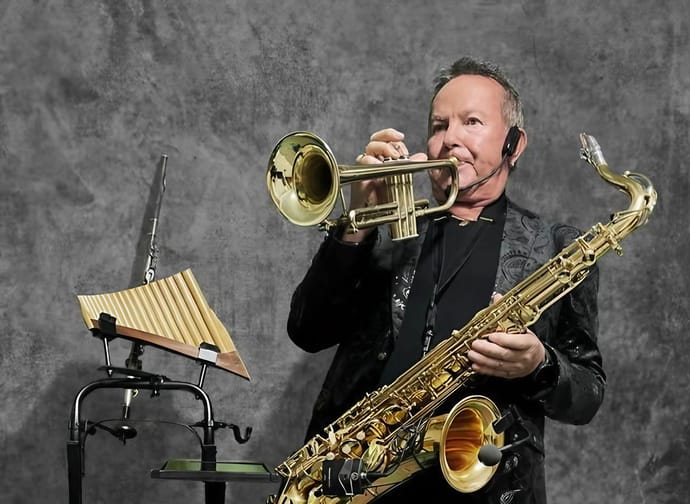 The picture shows Harry Wudler with instruments such as the saxophone and trumpet, as well as a pan flute.