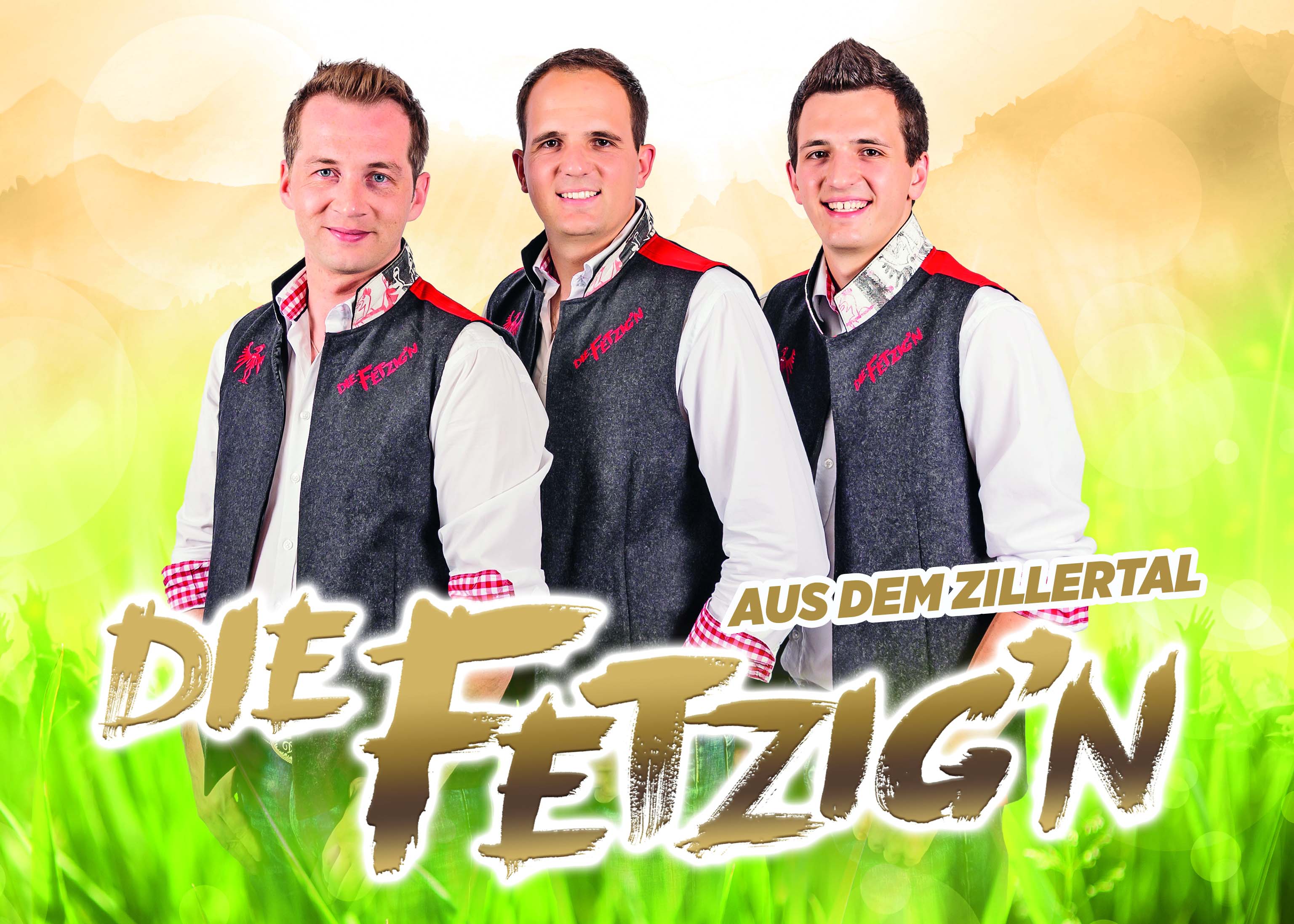 Drei junge Männer in Trachtenjacken vor buntem, fröhlichem Hintergrund, lächelnd für ein Gruppenfoto.