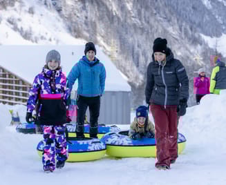 Family preparing for a snow tubing ride at Winterzauber Ginzling in the Zillertal, enjoying a fun and family-friendly winter activity in the snow.