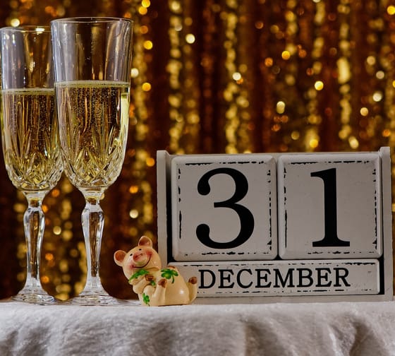 The picture shows two champagne glasses and the date 12/31 for New Year’s Eve.