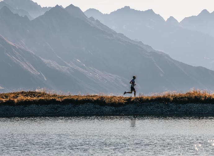 Läufer am See mit Berge im Hintergrund
