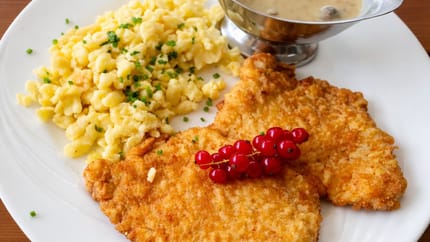 Ein Wiener Schnitzel mit Spätzle und Champignonsauce