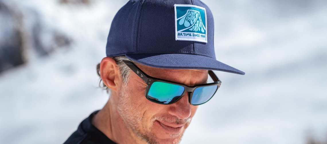 Man stands on the mountain wearing the PenkenPark cap