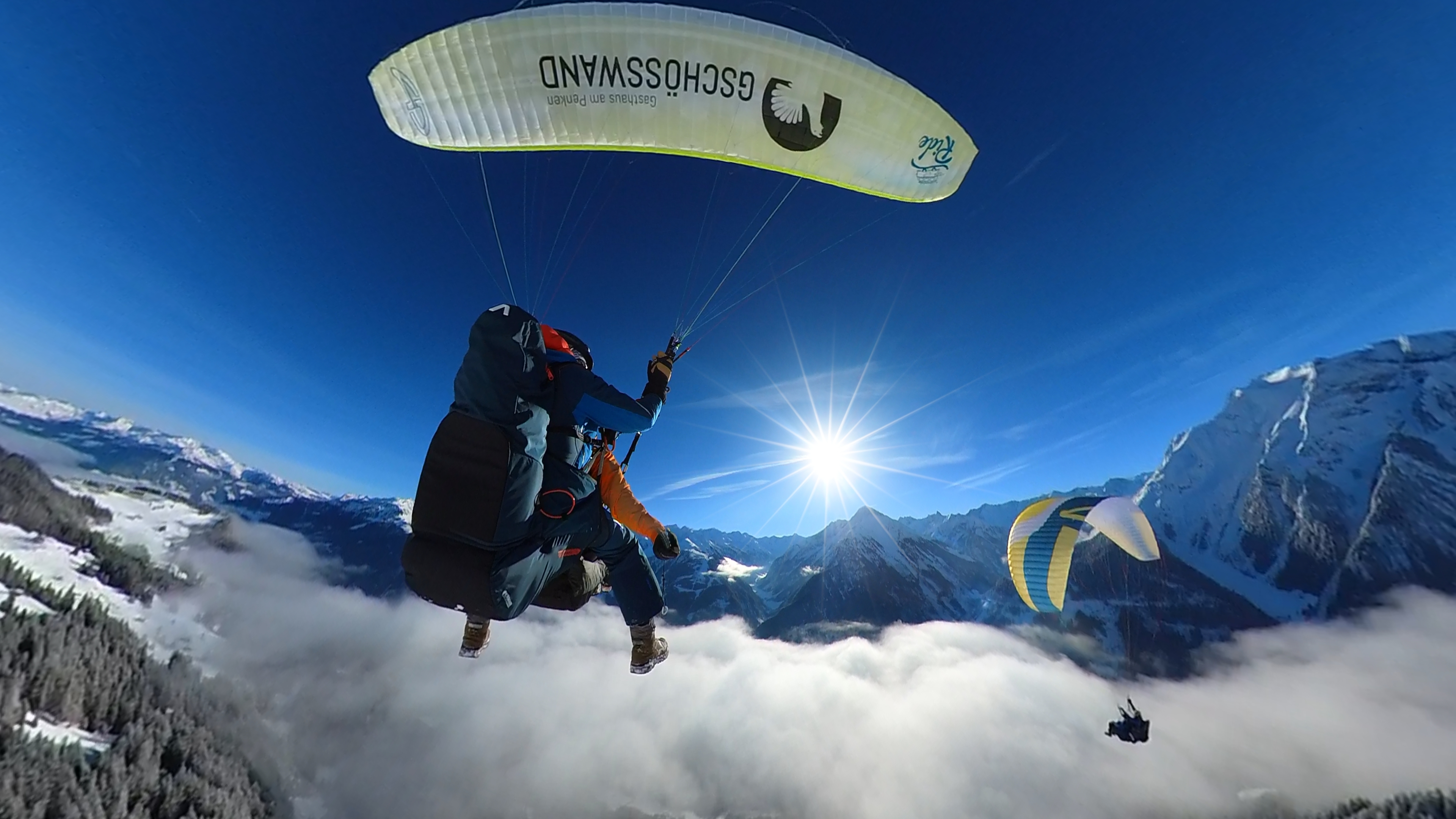 Tandem flight above the clouds. Sunshine and blue skies in the background.