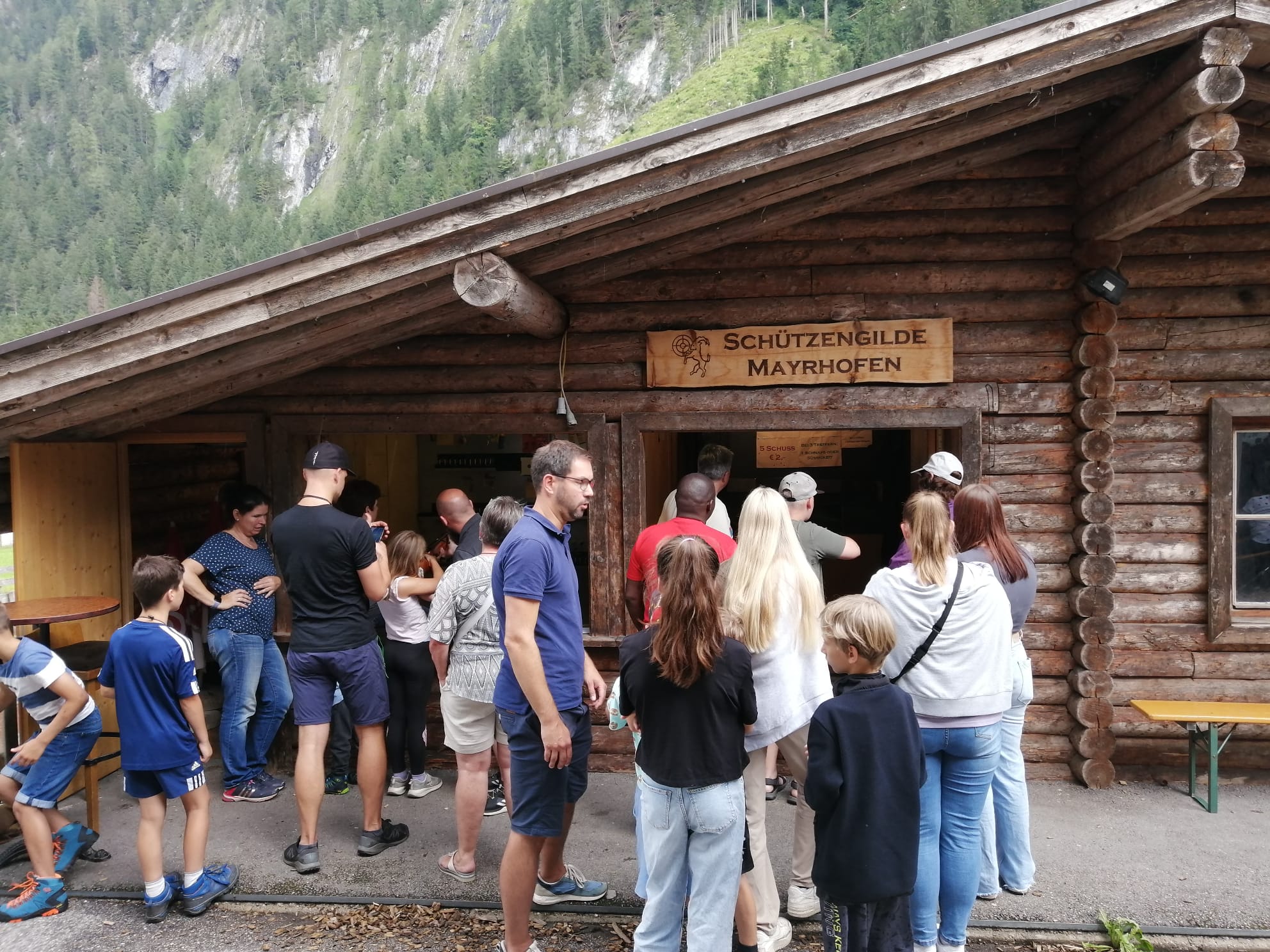 Das Bild zeigt die Schießbude der Schützengilde Mayrhofen mit Besuchern im Vordergrund.