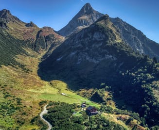 Green mountain landscape in Brandberg in the Zillertal valley, showing the mountain called Brandberger Kolm, which rises steeply into the sky.