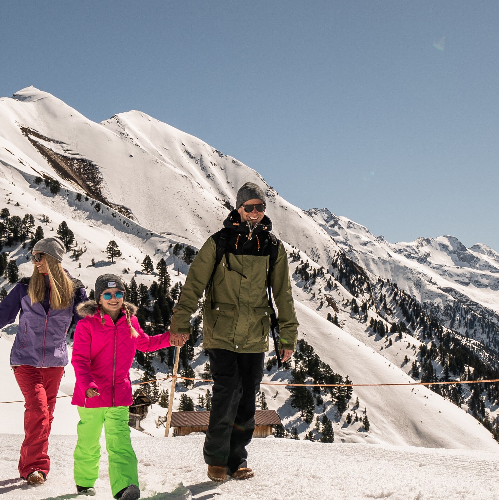 Eine Familie genießt beim Winterwandern am Ahorn in Mayrhofen die verschneite Berglandschaft auf einem sonnigen, präparierten Wanderweg mit Blick auf die Zillertaler Alpen.