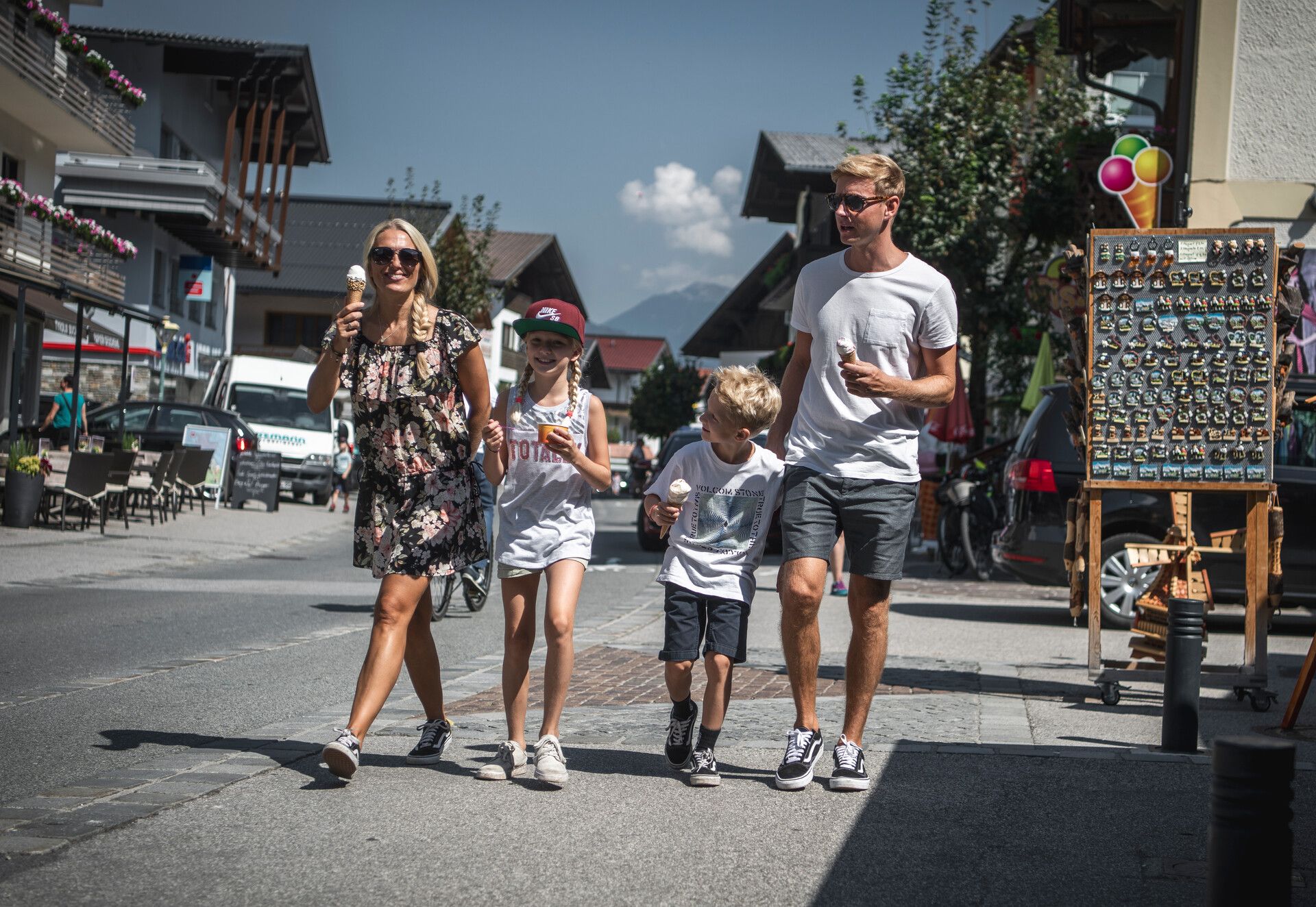 Hauptstraße Mayrhofen Family - mom, dad and 2 children, a boy and a girl, walk along Mayrhofen's main street with an ice cream.
