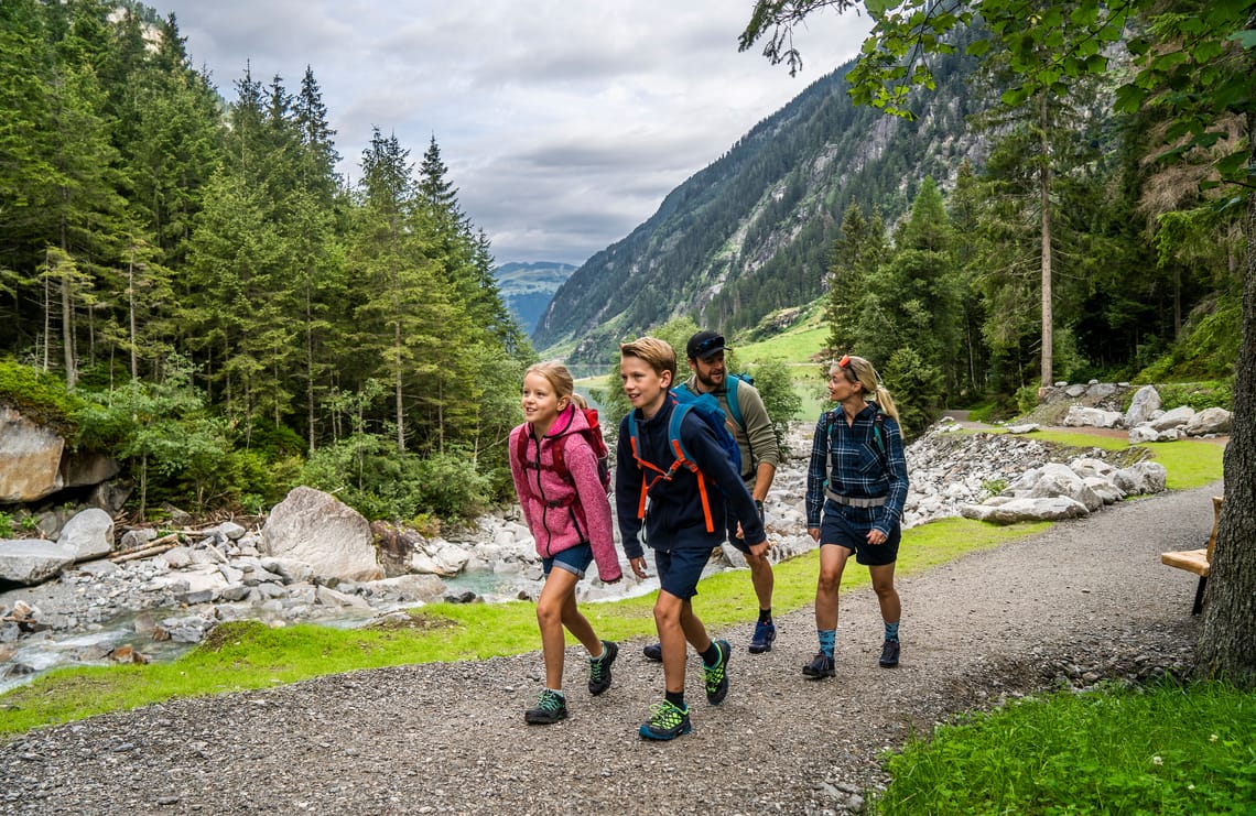Hiking in the Stilluptal Valley Family hiking on the Waterfall Trail in scenic Stilluptal, holiday region Mayrhofen-Hippach, surrounded by green meadows and majestic mountains.