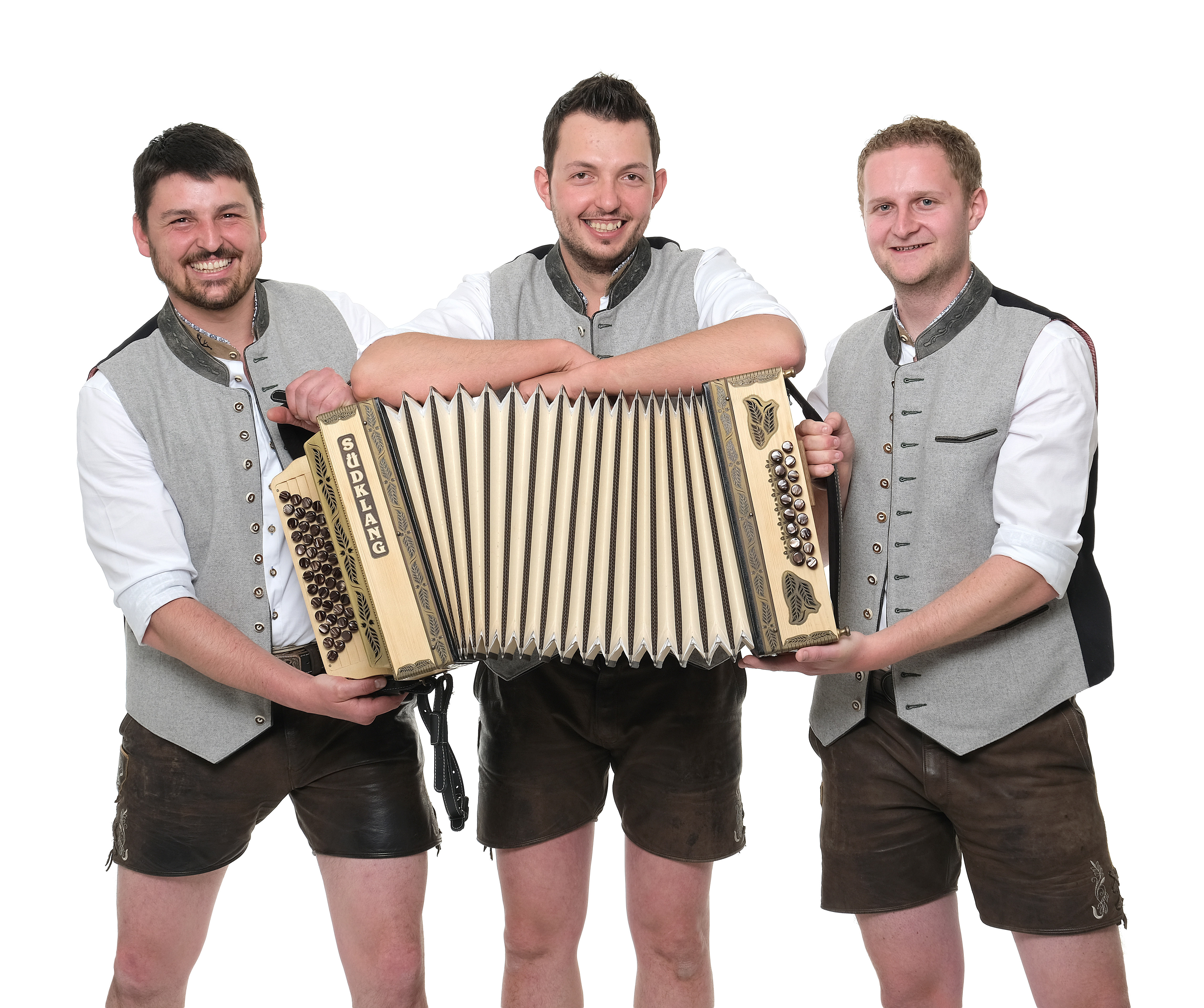 The image shows the music group Schneidig & Echt in a group photo with an accordion in the foreground.
