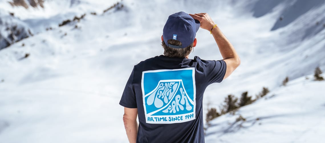 Mann steht mit den PenkenPark Shirt auf dem Berg