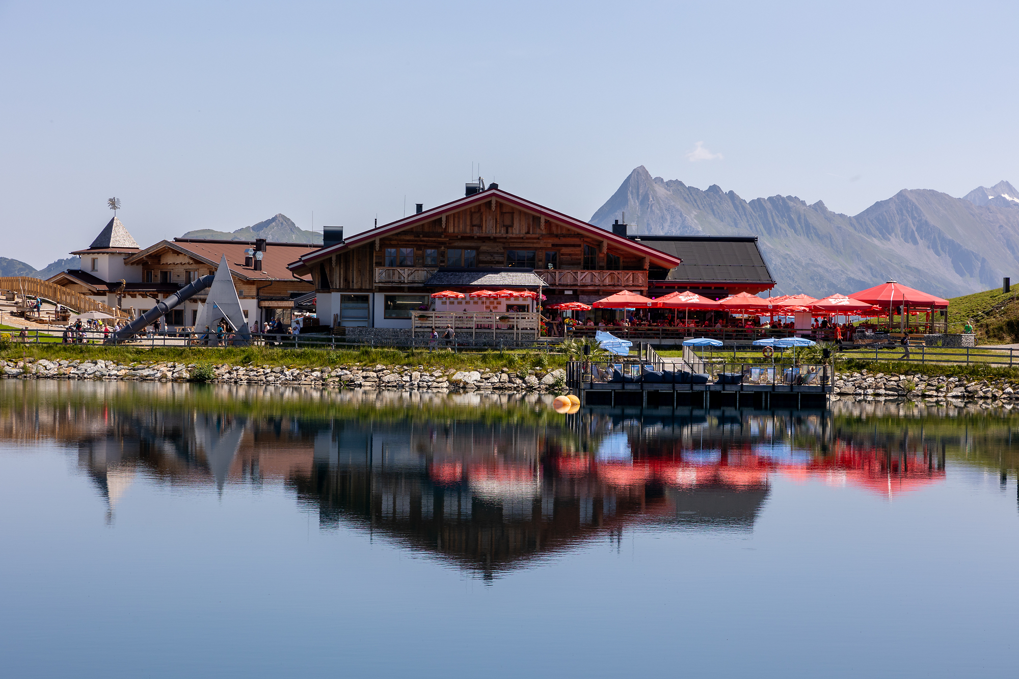Das Bild zeigt das Kasermandl am Penken mit einer Terasse und einem Speichersee im Hintergrund.