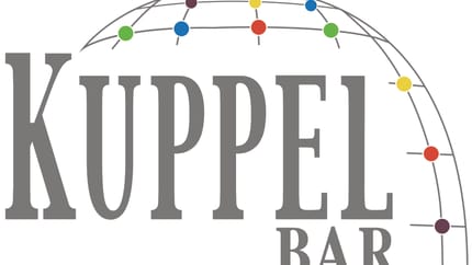Das Bild zeigt das Logo der "Kuppel Bar" in grauer Schrift mit farbigen Punkten im Logo