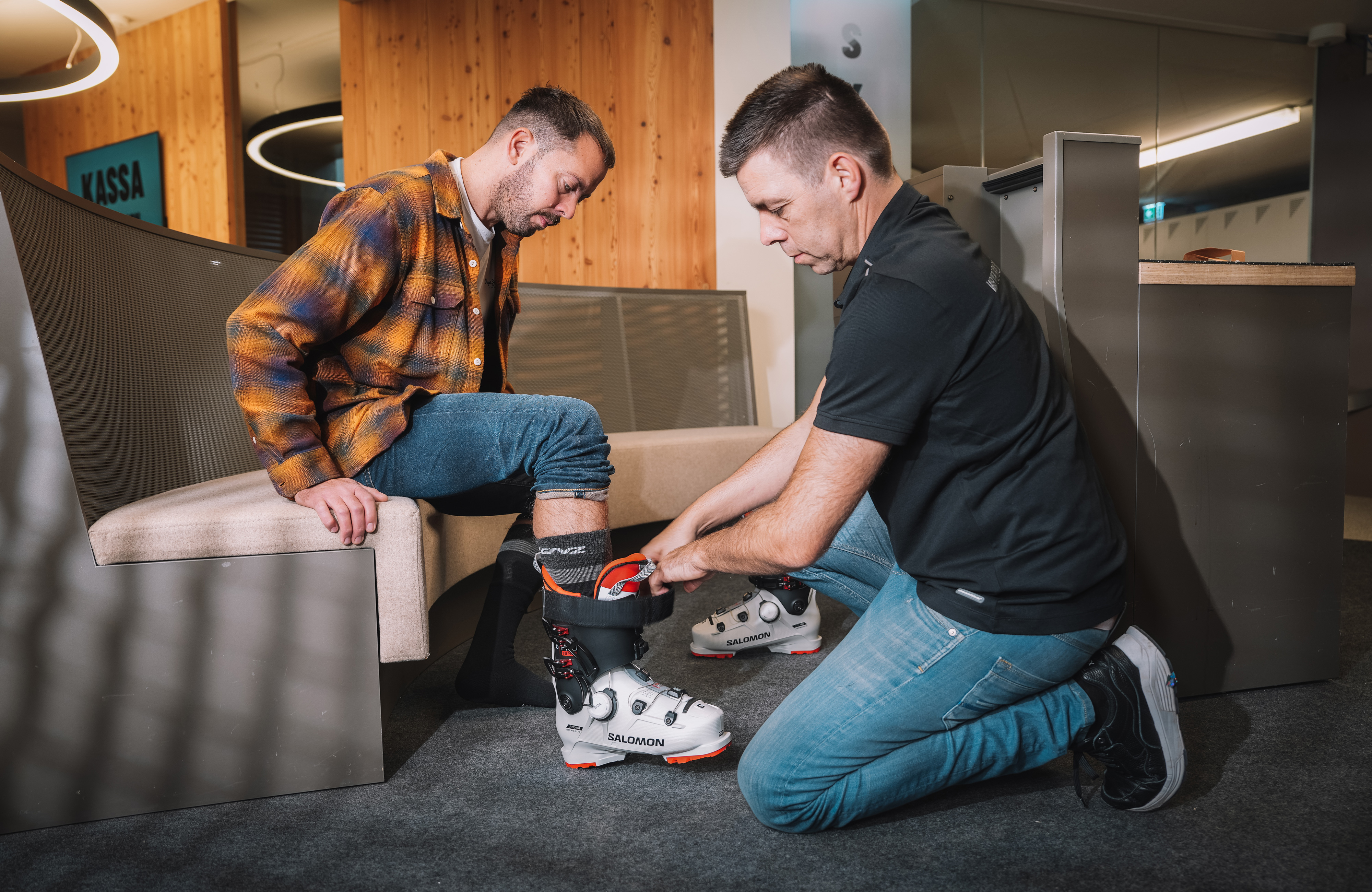 Skischuhverleih im Zillertal, Tirol: Mitarbeiter passt einem Gast den Skischuh an – professioneller Service für Skifahren im Winterurlaub in Mayrhofen-Hippach.