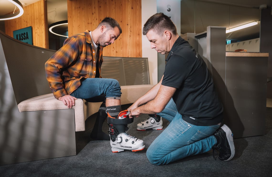 Skiverleih im Zillertal ©Zillertaltourismus | Josef Unterlercher Skischuhverleih im Zillertal, Tirol: Mitarbeiter passt einem Gast den Skischuh an – professioneller Service für Skifahren im Winterurlaub in Mayrhofen-Hippach.