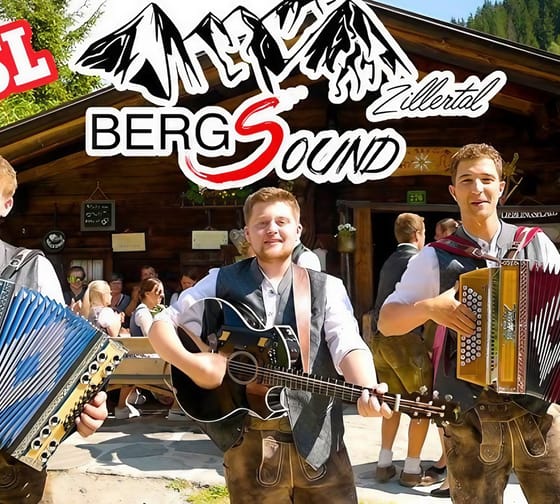 Drei junge Männer mit Akkordeons und Gitarre vor einem Holzhaus, bei Bergsound Zillertal, im Freien, fröhlich und in Trachten.