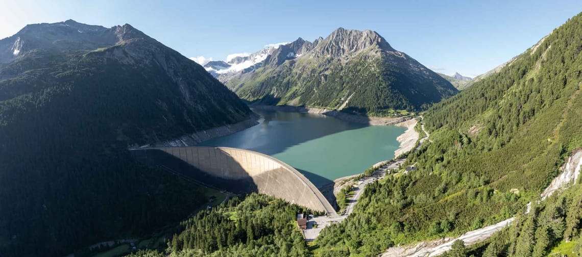The dam of the Schlegeis Reservoir, surrounded by mountains and forest