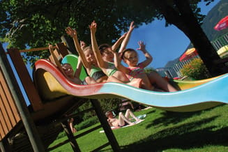 Children on the slide at the playground in the outdoor pool Mayrhofen