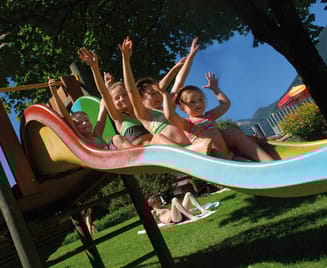 Children on the slide at the playground in the outdoor pool Mayrhofen