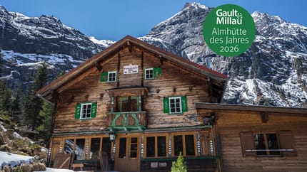 Die Grawandhütte in the rear Zemmgrund valley near Mayrhofen in the Zillertal valley stands in front of snow-covered mountains. A traditional wooden alpine hut with green shutters, surrounded by alpine winter landscape – a popular destination for hikers a