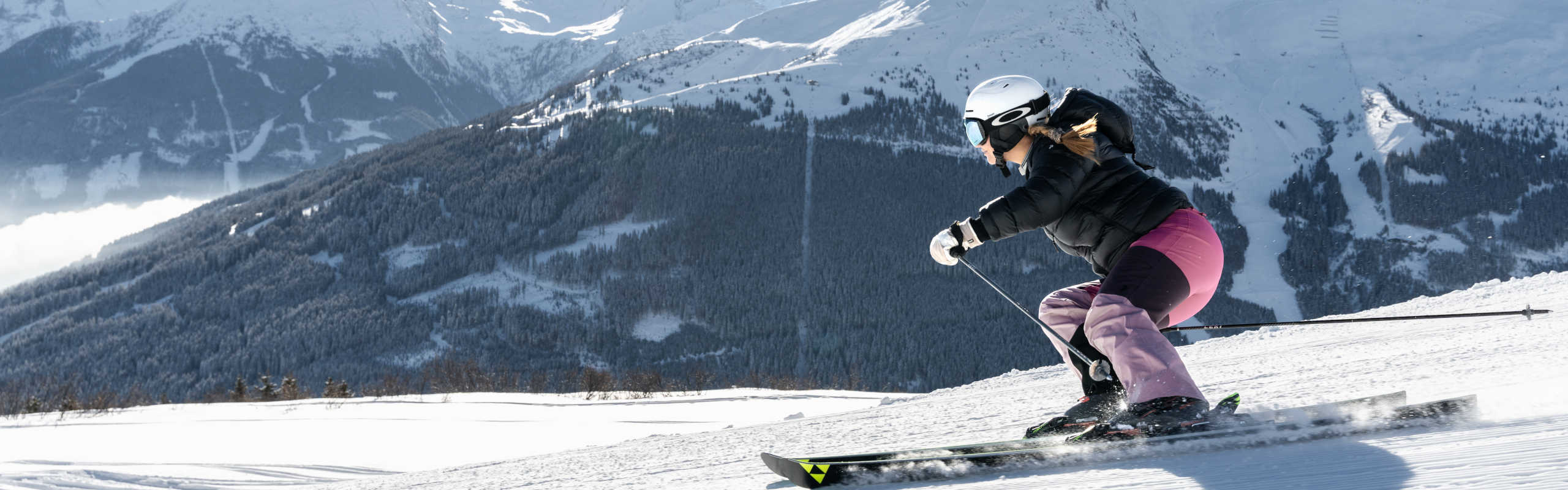 Carving on the Schlossalm in Gastein with a view of the snow-covered mountains of the Gastein Valley.