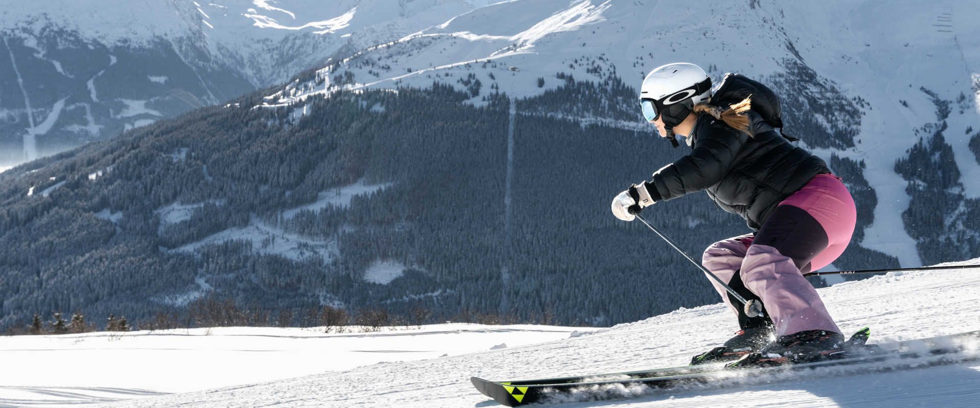 Carving on the Schlossalm in Gastein with a view of the snow-covered mountains of the Gastein Valley.