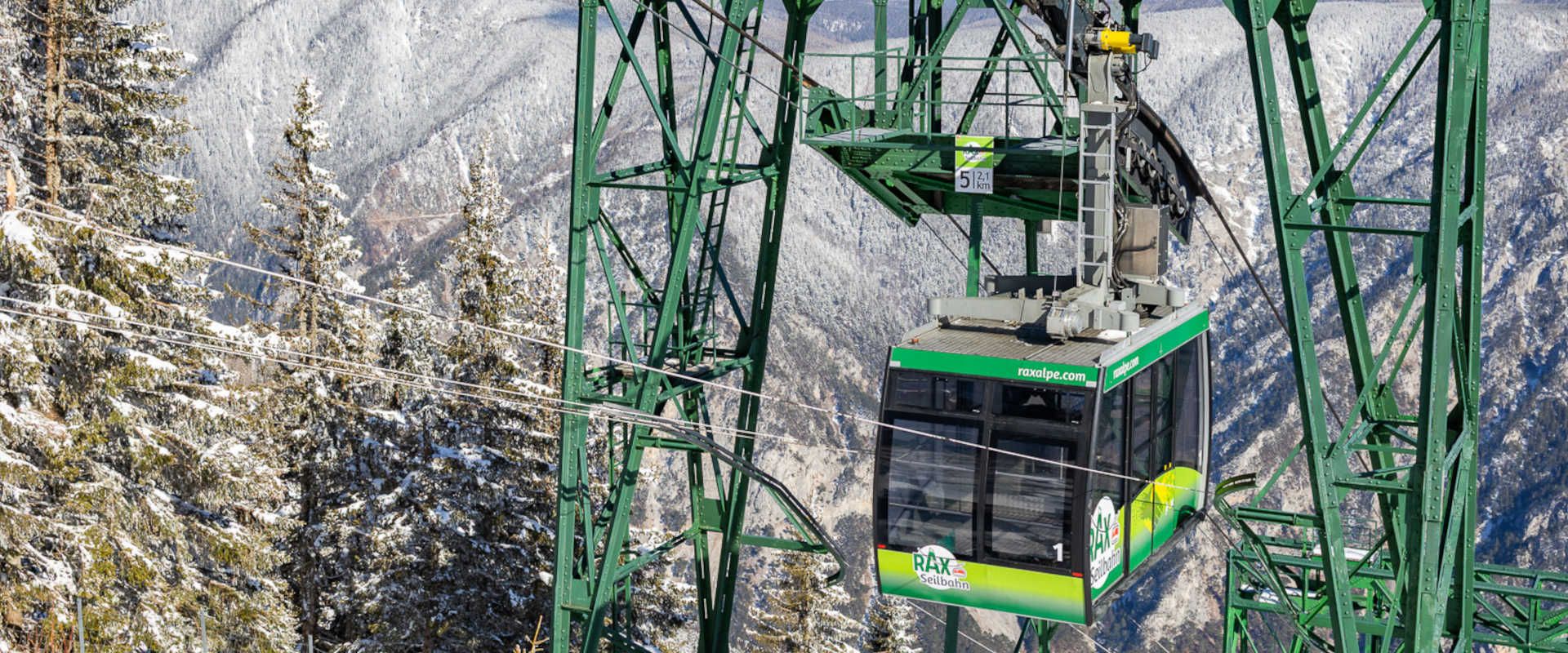 Rax-Seilbahn auf der Raxalpe in winterlicher Bergkulisse mit verschneiten Wäldern.