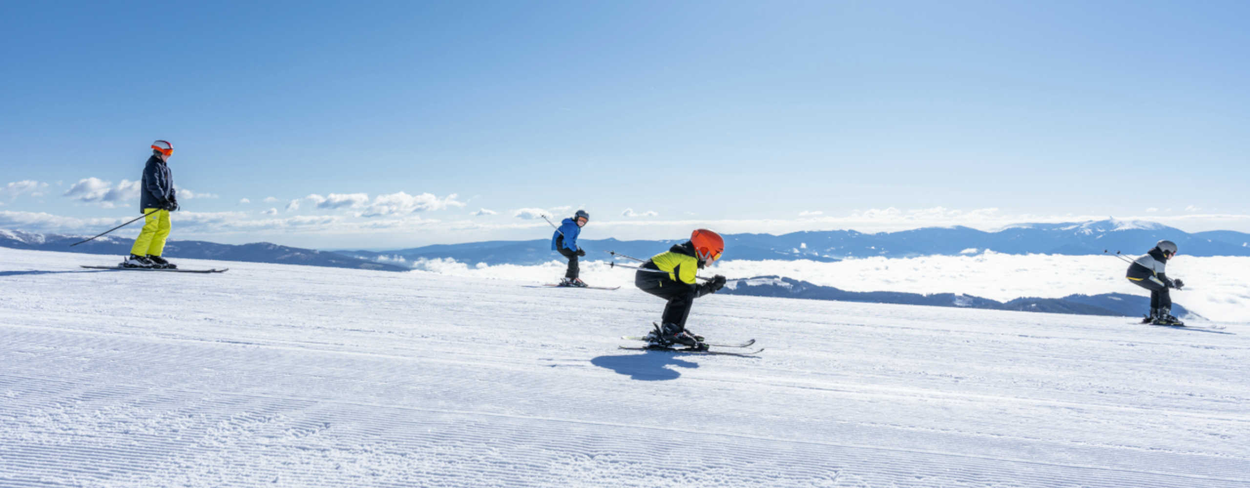 Skiing at Klippitztörl in Carinthia: Winter sports enthusiasts enjoy perfectly groomed slopes in the sunshine, surrounded by an impressive Alpine panorama.