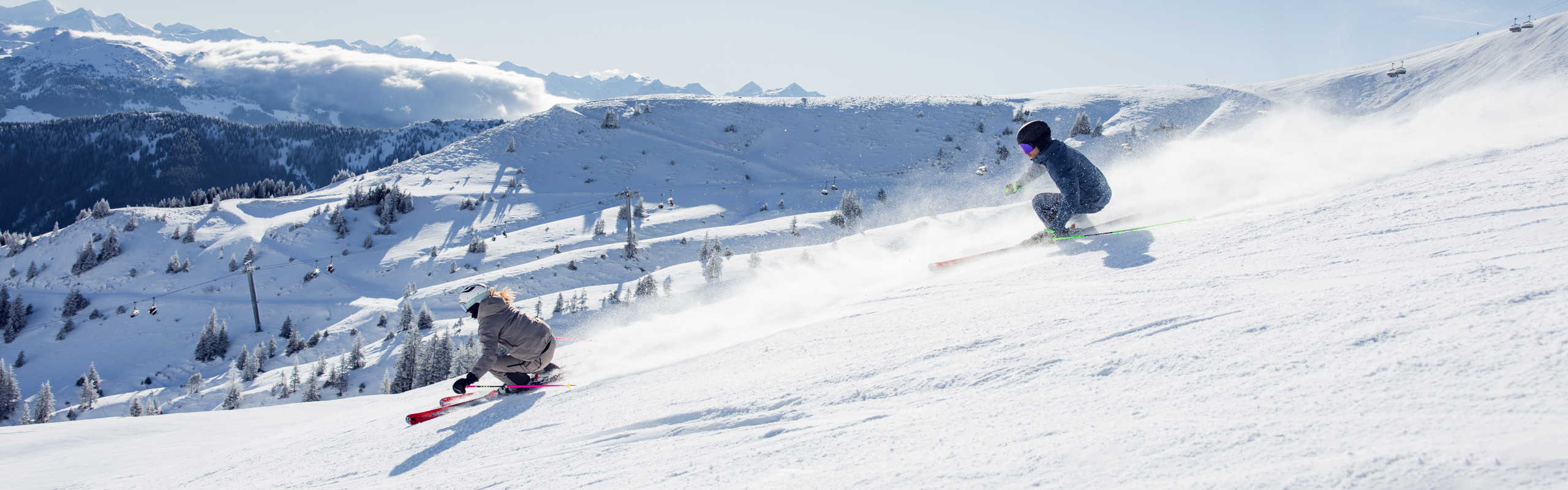 Skiing in Kitzbühel on a sunny slope with a view of the snow-covered Kitzbühel Alps.