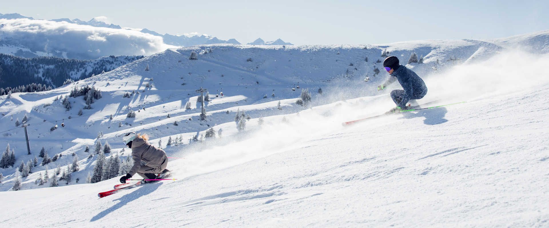 Skiing in Kitzbühel on a sunny slope with a view of the snow-covered Kitzbühel Alps.