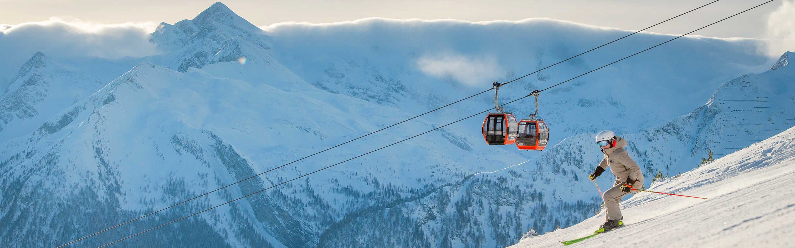 Spring skiing on the Stubnerkogel in Ski Gastein, featuring a gondola lift and an impressive Alpine panorama.