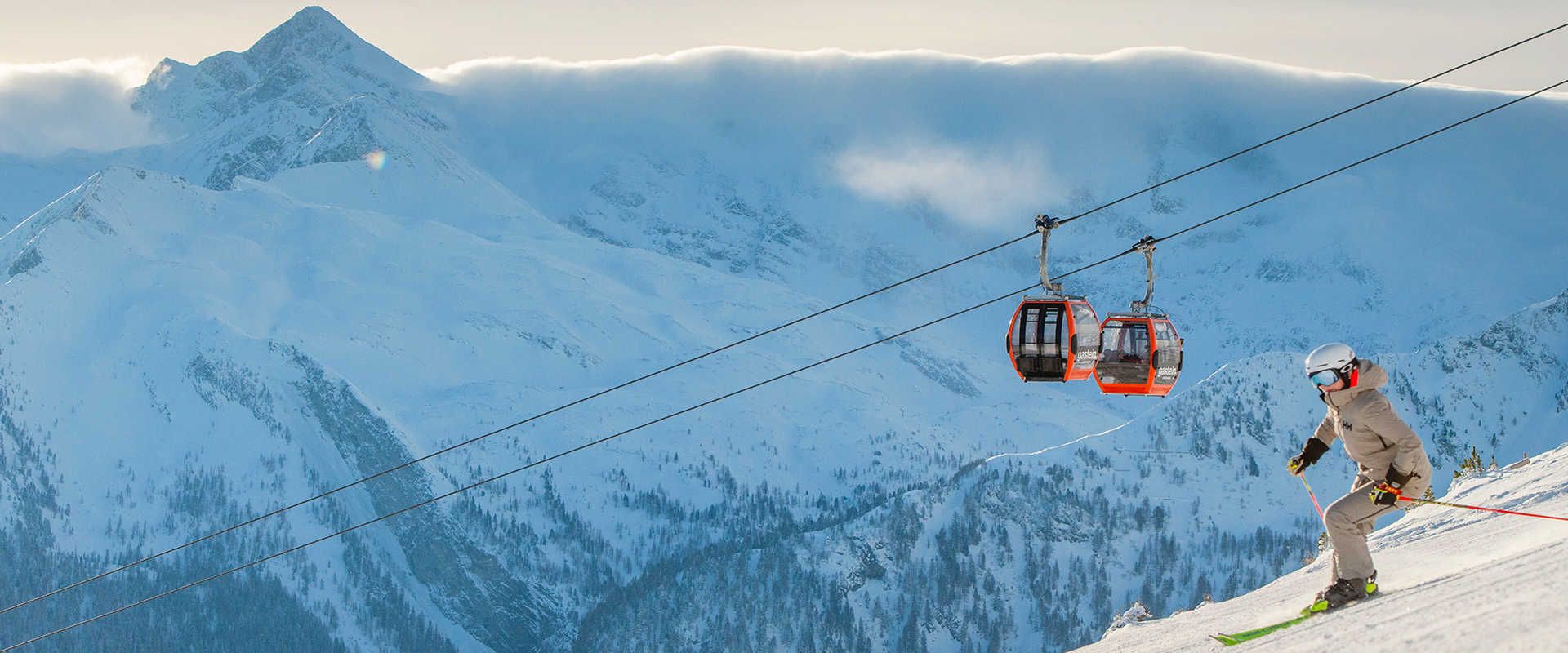 Spring skiing on the Stubnerkogel in Ski Gastein, featuring a gondola lift and an impressive Alpine panorama.