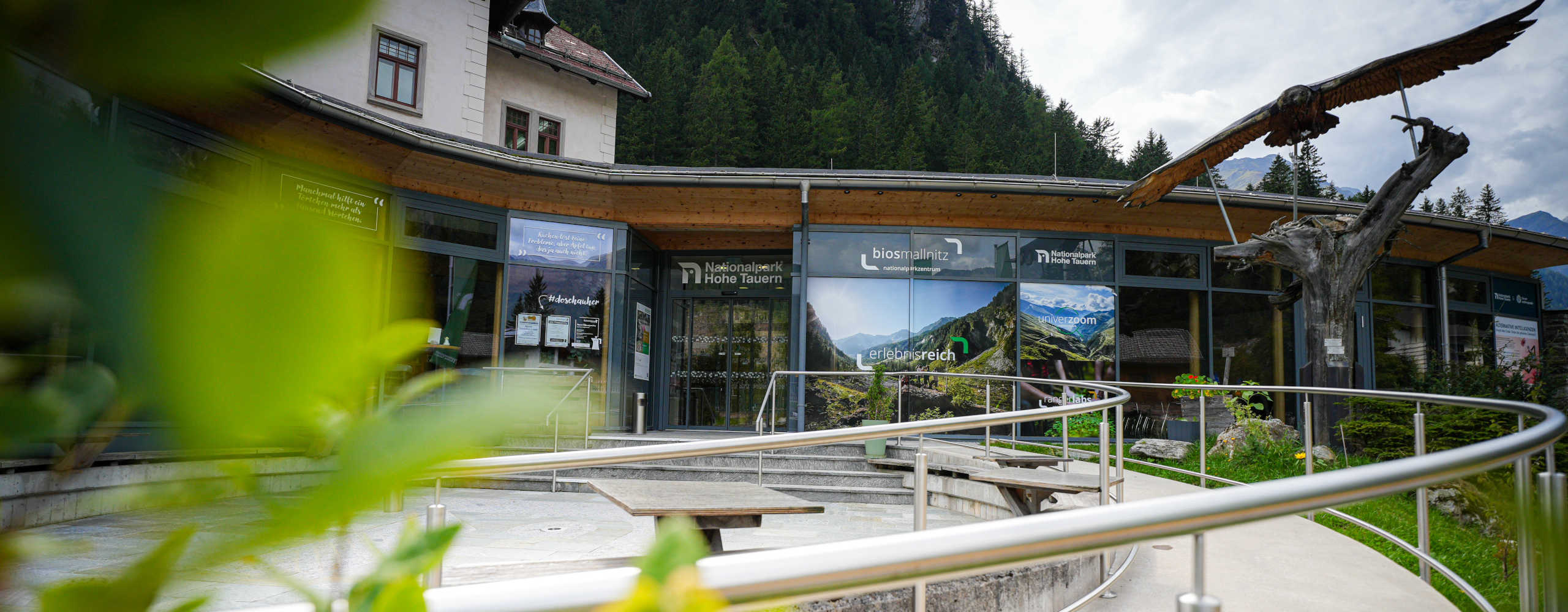 BIOS Nationalparkzentrum Mallnitz im Nationalpark Hohe Tauern mit modernem Eingangsbereich und barrierefreiem Zugang inmitten der alpinen Berglandschaft.