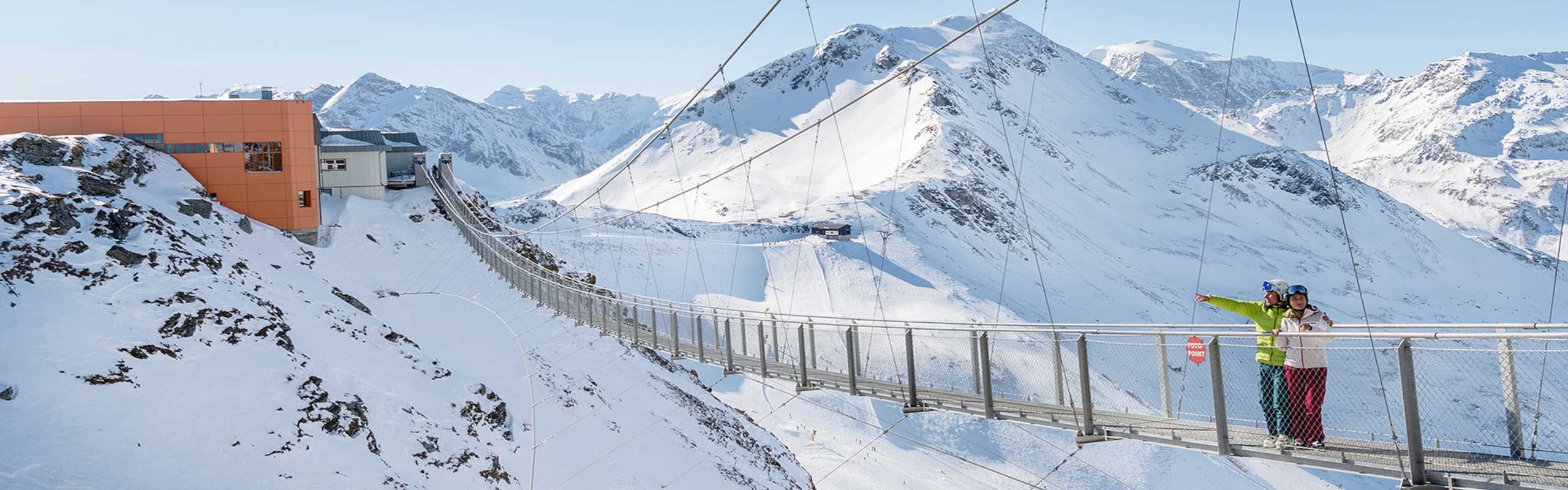 Suspension bridge on the Stubnerkogel in Bad Gastein, set against a stunning winter Alpine panorama.
