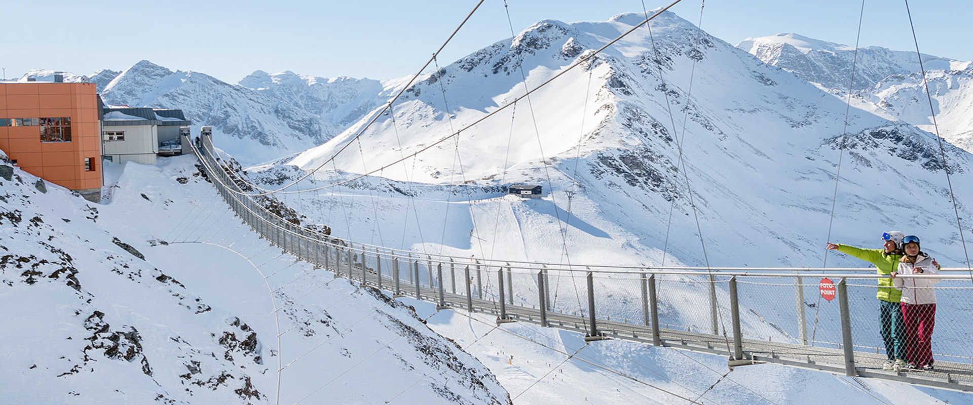 Suspension bridge on the Stubnerkogel in Bad Gastein, set against a stunning winter Alpine panorama.