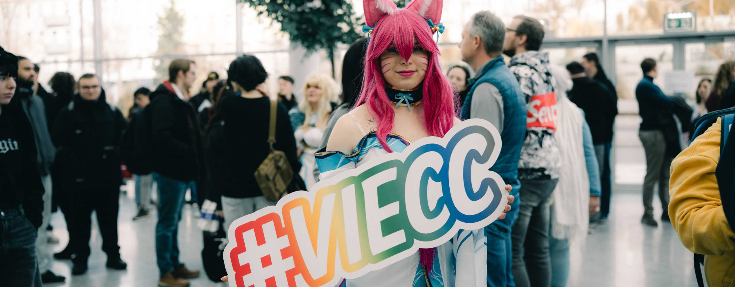 Coyplayerin präsentiert ein Schild mit #VIECC