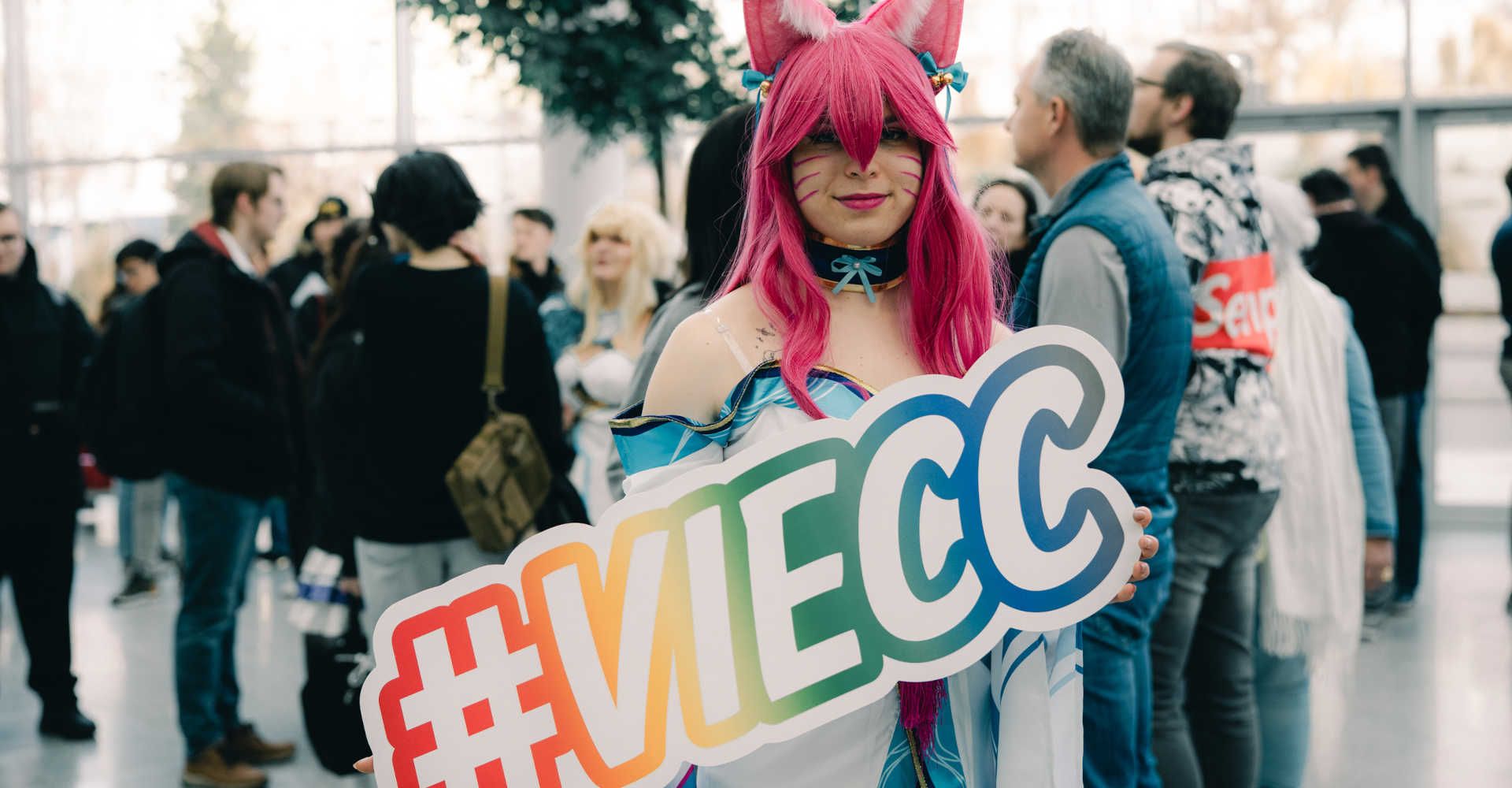 Coyplayerin präsentiert ein Schild mit #VIECC