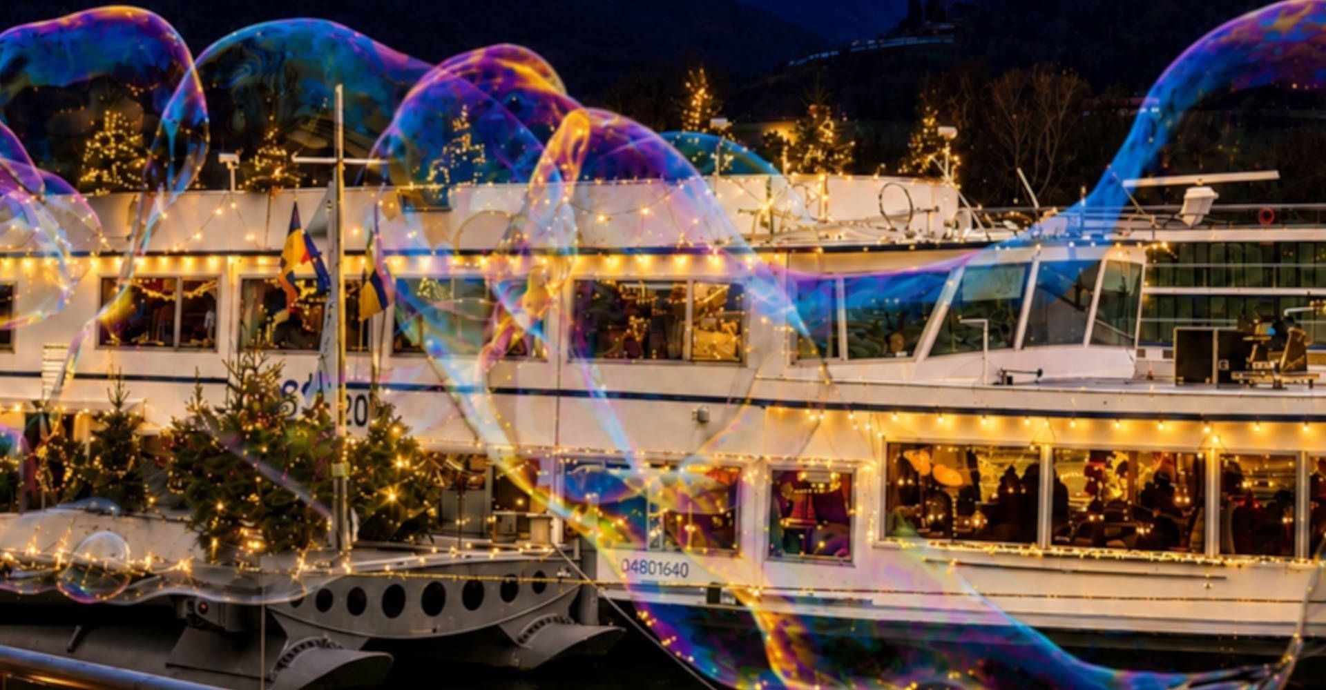 A ship decorated for Christmas behind a large soap bubble