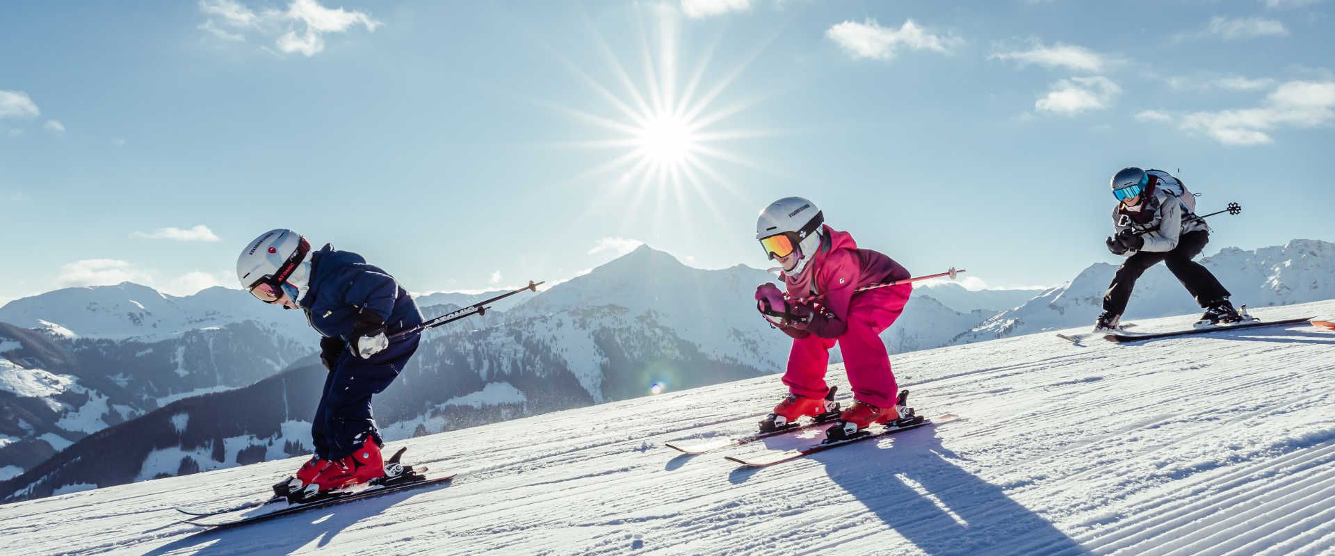 Familienskifahren im Ski Juwel Alpbachtal Wildschönau vor winterlichem Alpenpanorama.