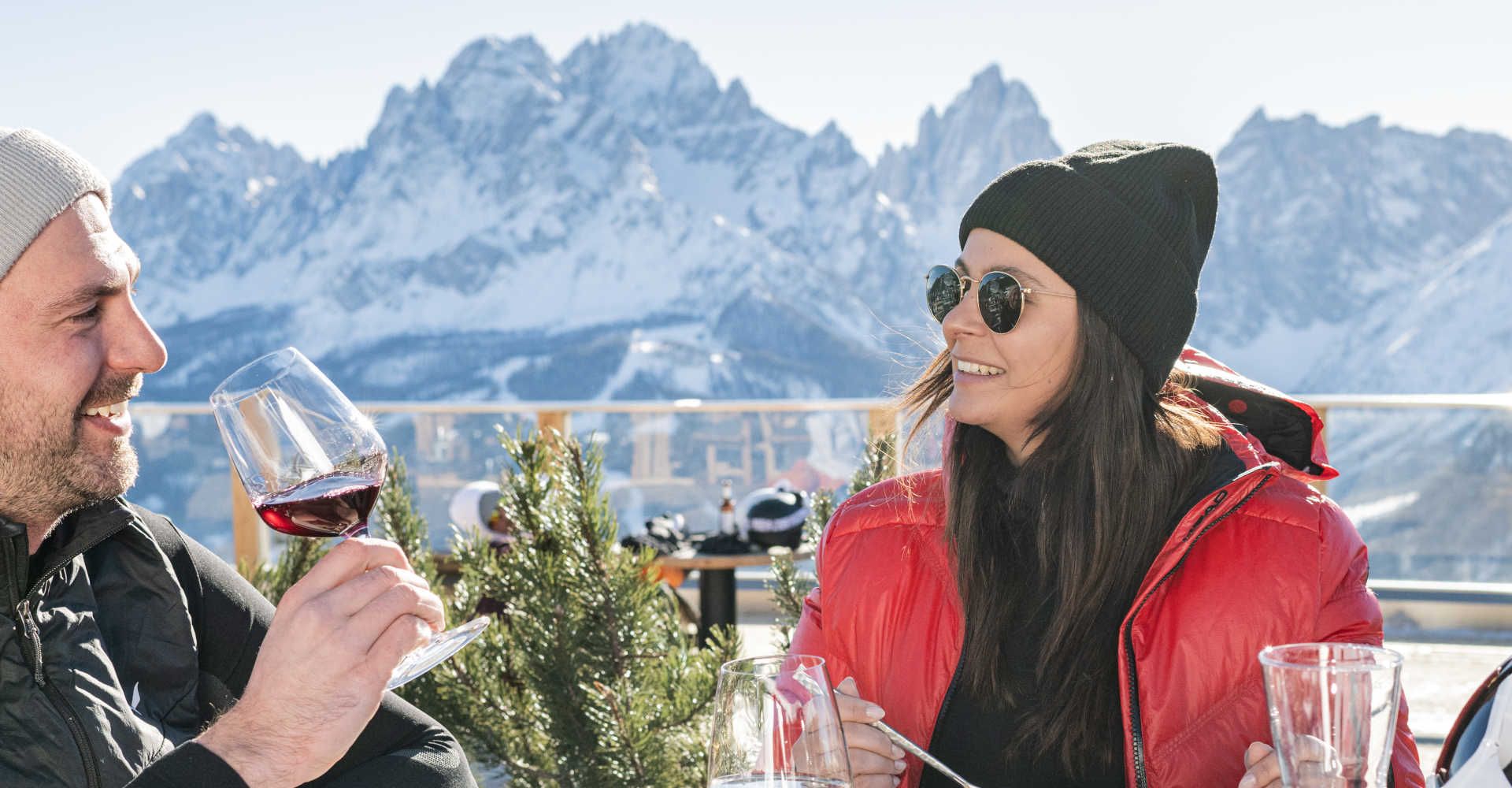 Guests enjoy a sun terrace in the Three Peaks Dolomites with a spectacular view of the snow-capped mountains.