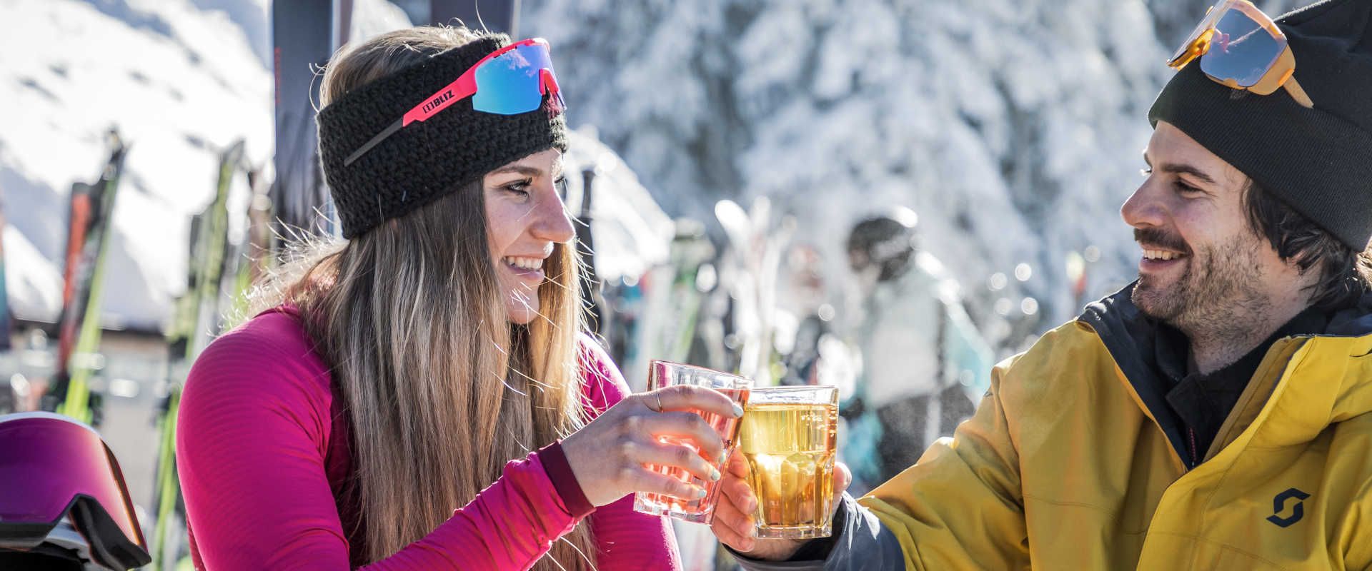 A break on the Planai in Schladming with hot drinks and ski gear against a wintry mountain backdrop.
