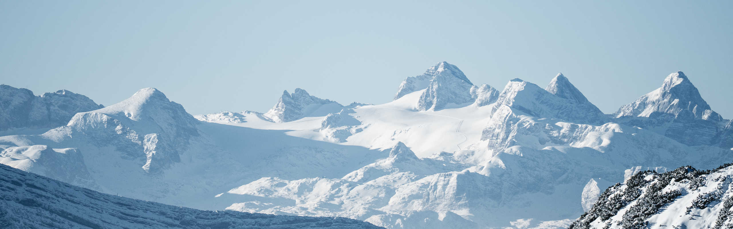 A wintry panorama of the Dachstein with snow-capped peaks and glacial landscapes in the Alps.