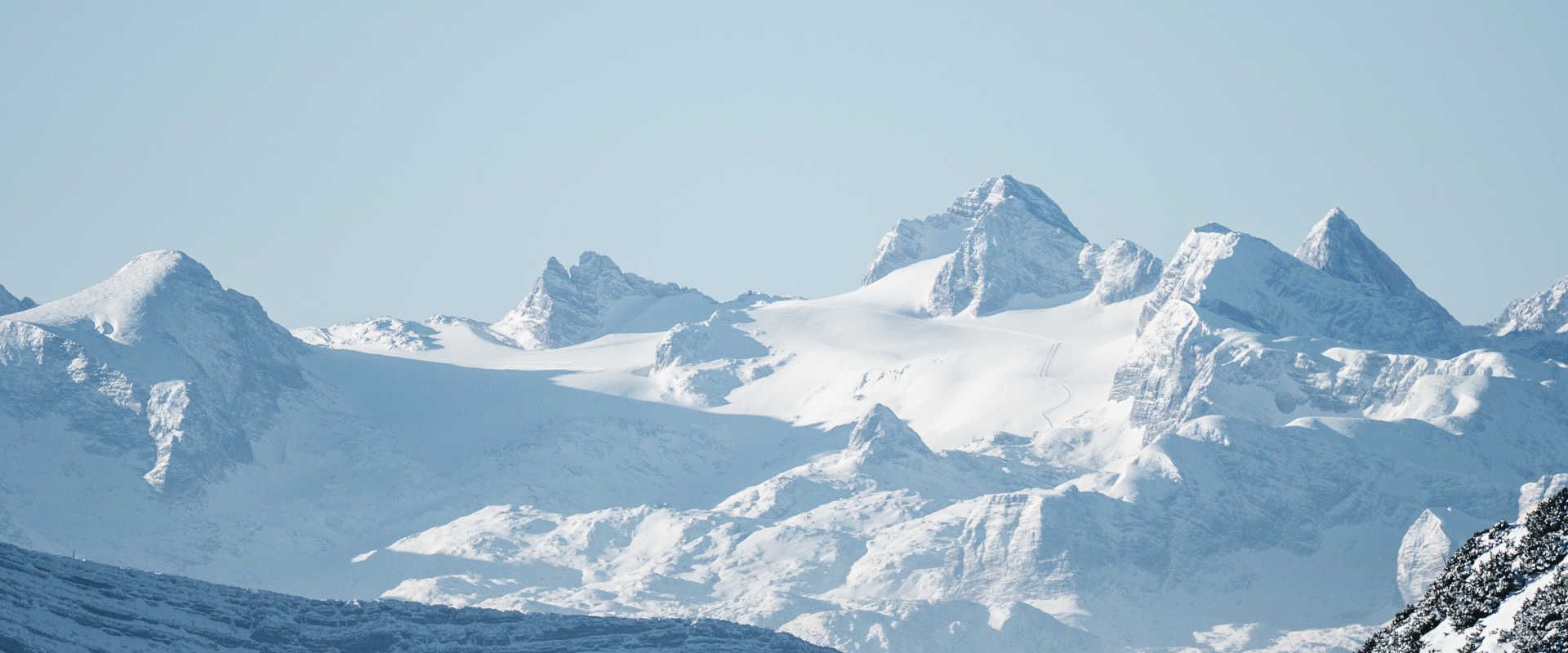 A wintry panorama of the Dachstein with snow-capped peaks and glacial landscapes in the Alps.