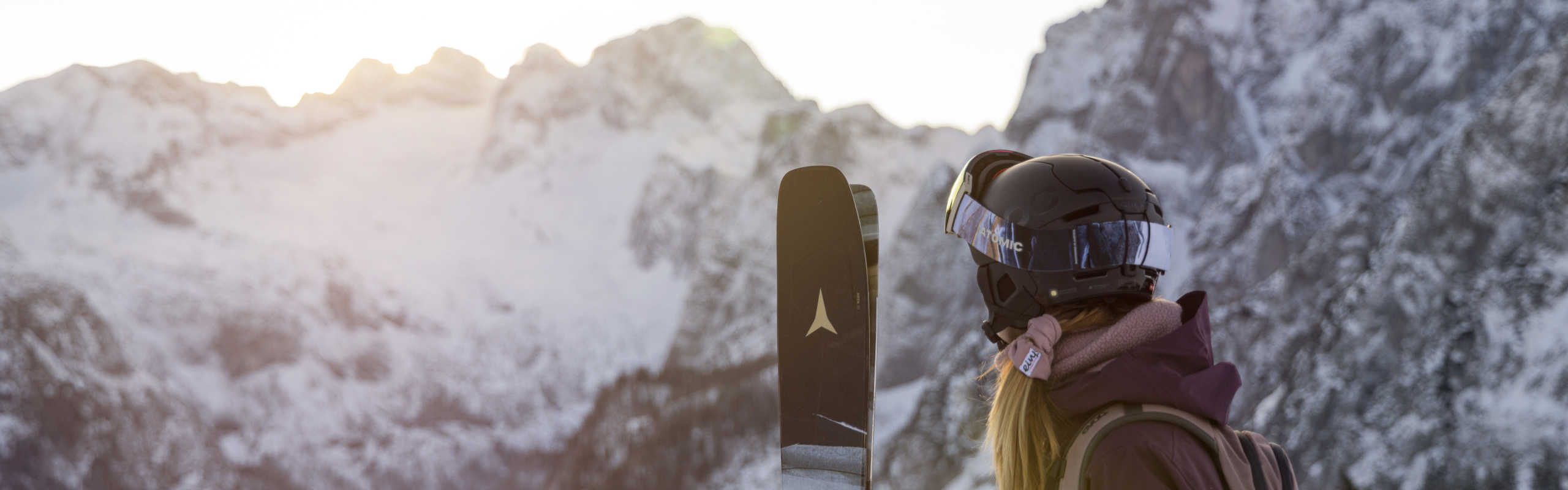 Ski gear against the backdrop of the Dachstein panorama, with snow-capped mountains and winter sunshine.